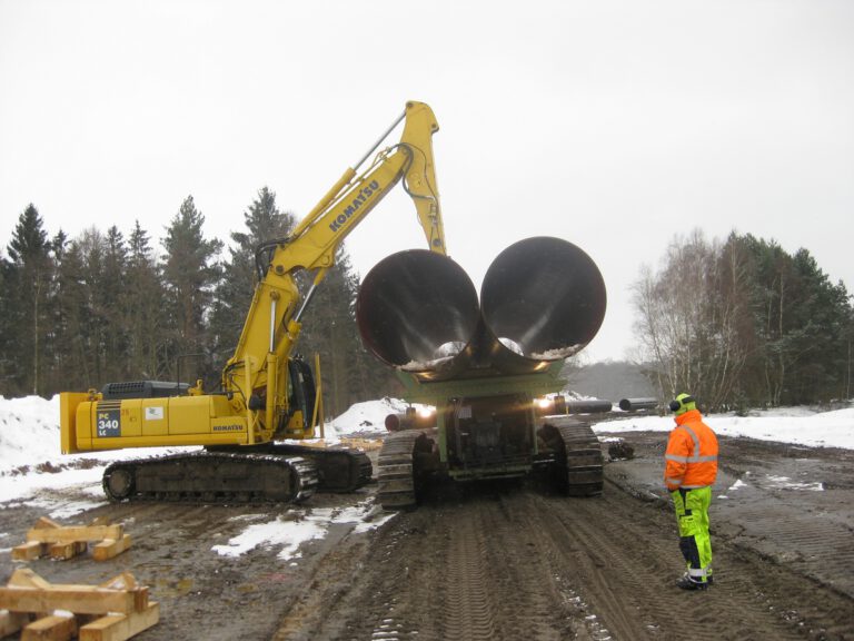 Aufladen von Rohren für den Spezialtransport im Schnee